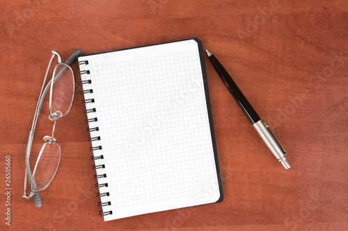 glasses, notepad with pen