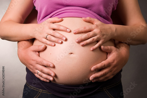 Foto of pregnant woman and her husband is in a studio