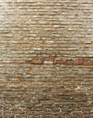 section of a very old worn gray painted brick wall