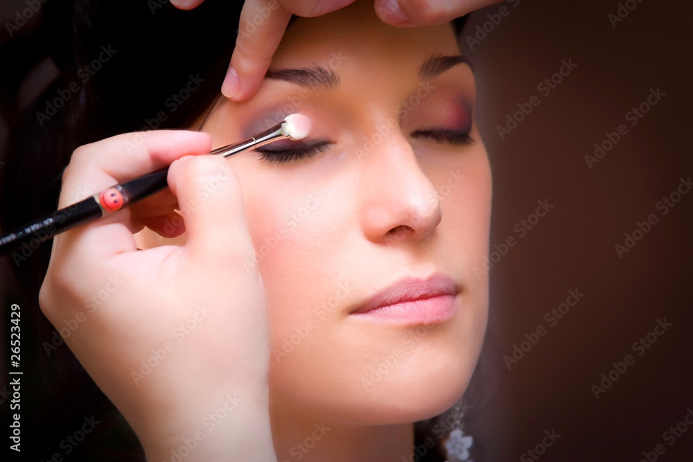 make up artist makeing a make up with an eye brush
