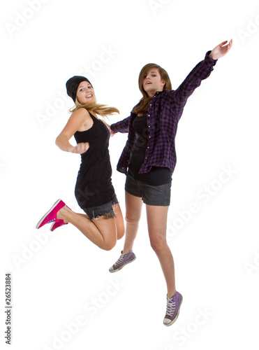 Two young teenage girls with trendy stylish clothes jumping
