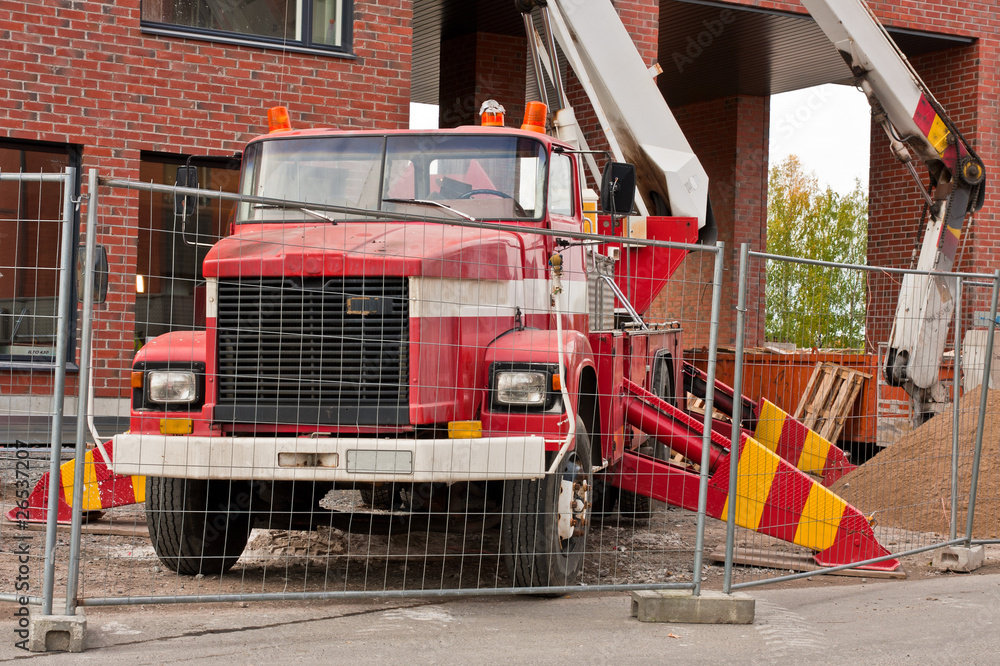 Fototapeta premium Old red platform lifter truck on construction site