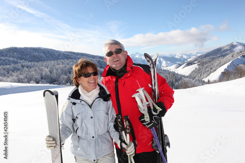Homme et femme seniors souriants à la neige