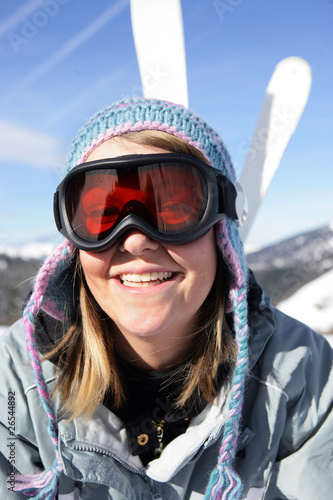 Jeune femme souriante portant un masque de ski à la neige
