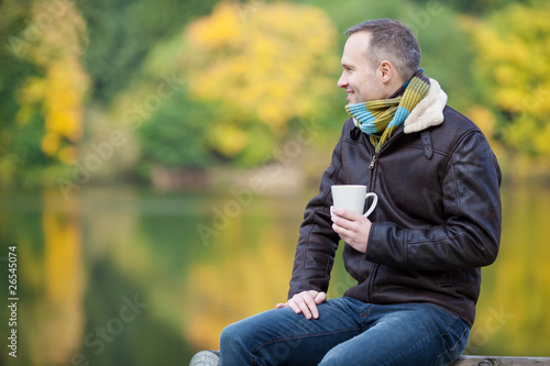 mann mit tasse am see photo