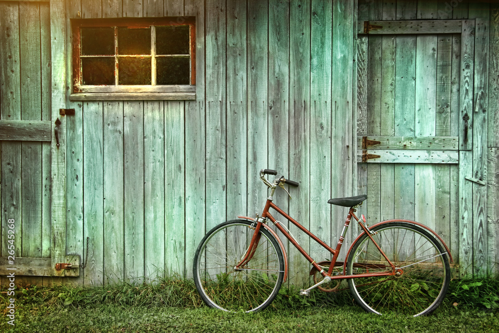 Naklejka premium Old bicycle leaning against grungy barn