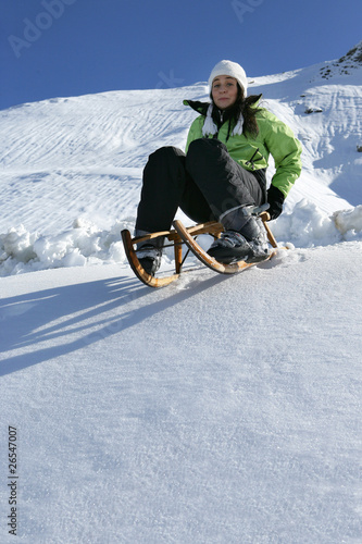 Jeune femme faisant de la luge à la neige