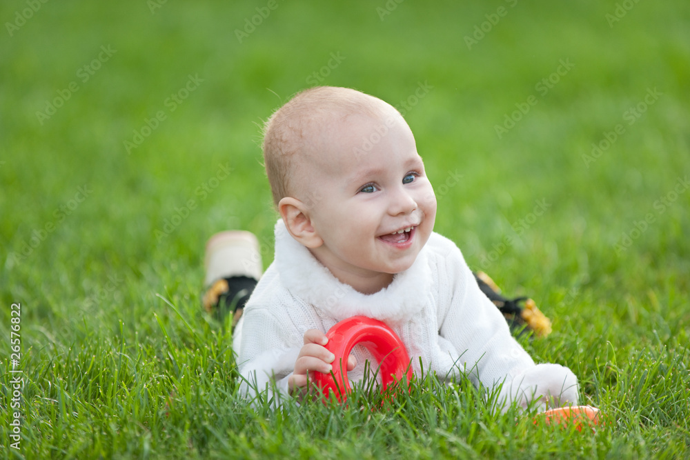 Smiling little girl in white on green grass Smiling little girl in white on green grass