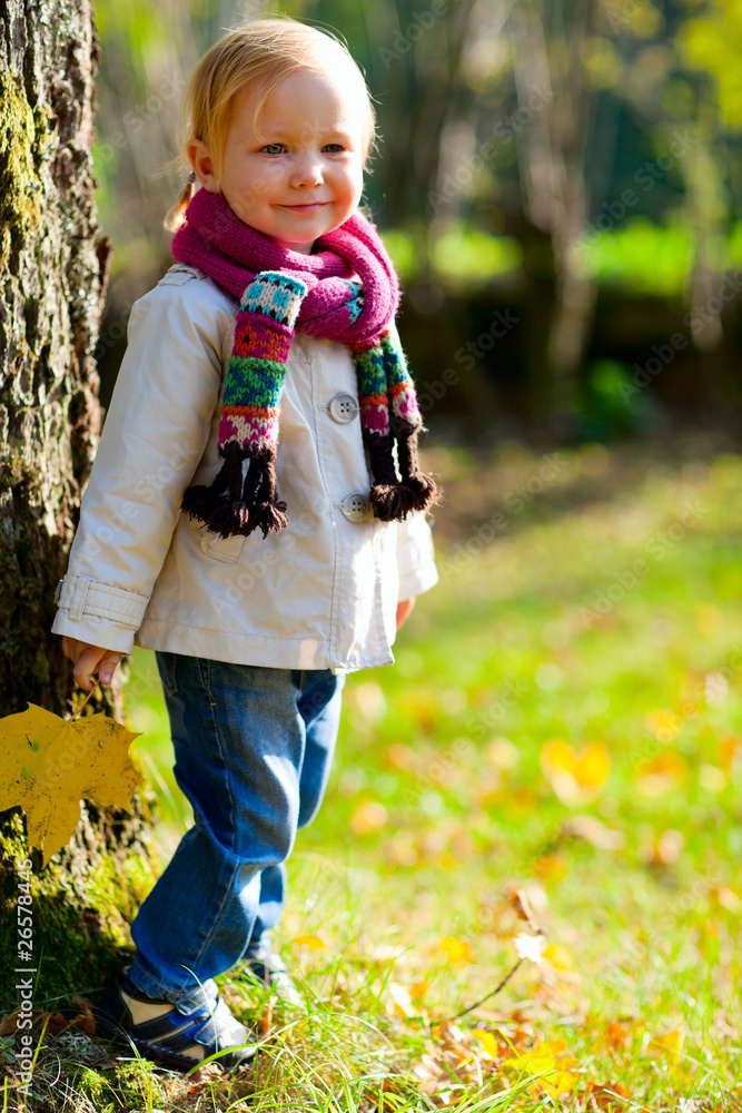 Toddler girl standing near tree Toddler girl standing near tree