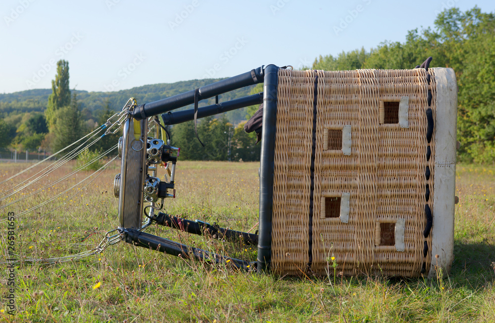Fototapeta premium Hot air balloon gondola lying on the ground, ready for the fligh