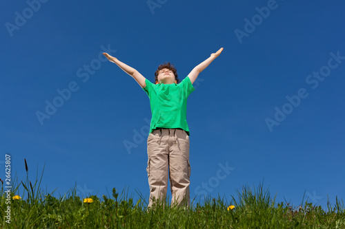 Hope - boy holding arms up against blue sky