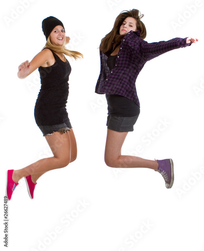 Two young teenage girls with trendy stylish clothes jumping.