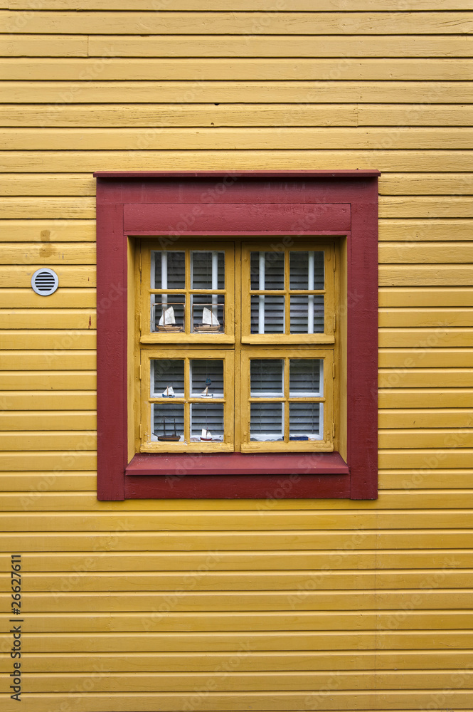Fototapeta premium Red window on a yellow wall