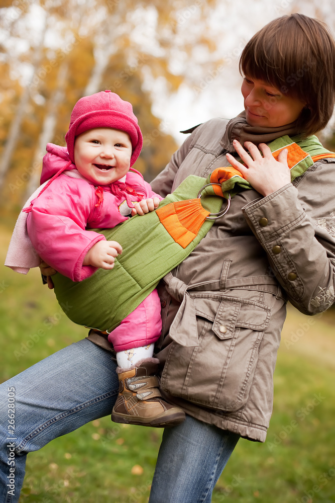 Fototapeta premium mother carrying daughter in sling