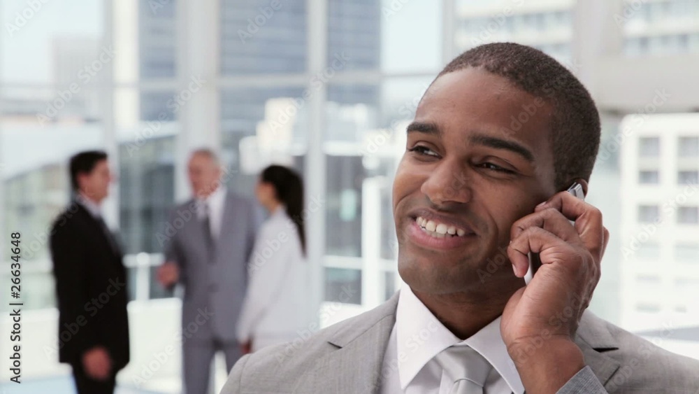 Handsome Businessman on a Cellphone in an Office Lobby Handsome Businessman on a Cellphone in an Office Lobby