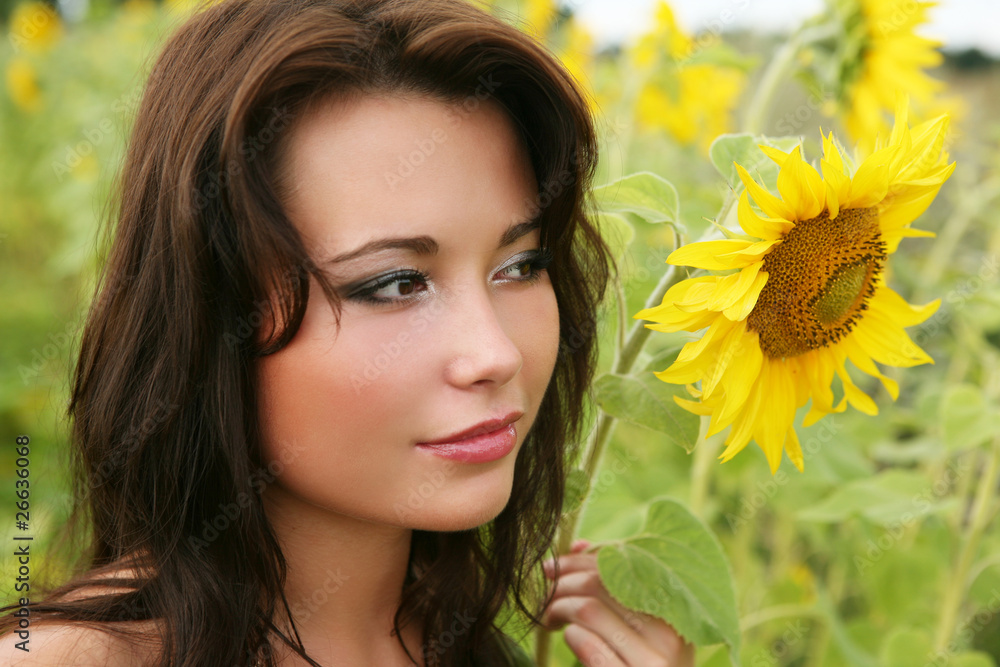 Naklejka premium The young woman with sunflowers.