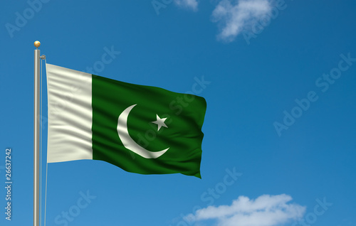 Flag of Pakistan waving in the wind in front of blue sky