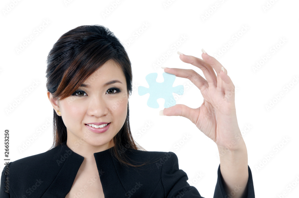 Attractive businesswoman holding a jigsaw puzzle Attractive businesswoman holding a jigsaw puzzle