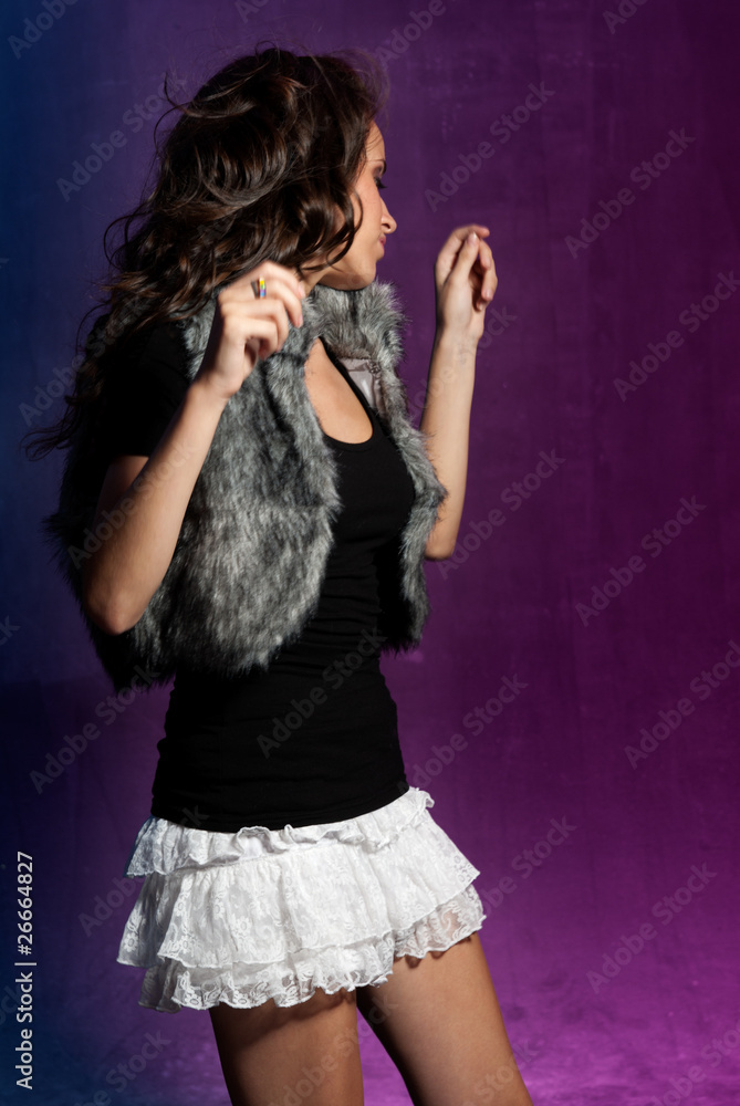 Young girl dancing at disco. Blue and purple background. Young girl dancing at disco. Blue and purple background.