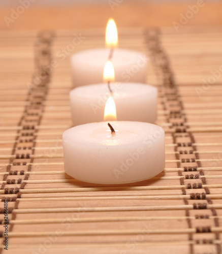 Three candles on a bamboo carpet