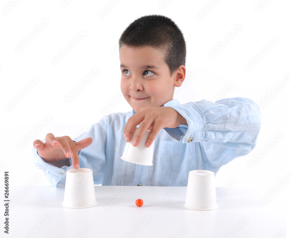 Cute boy playing traditional shell game with walnut shells. Cute boy playing traditional shell game with walnut shells.