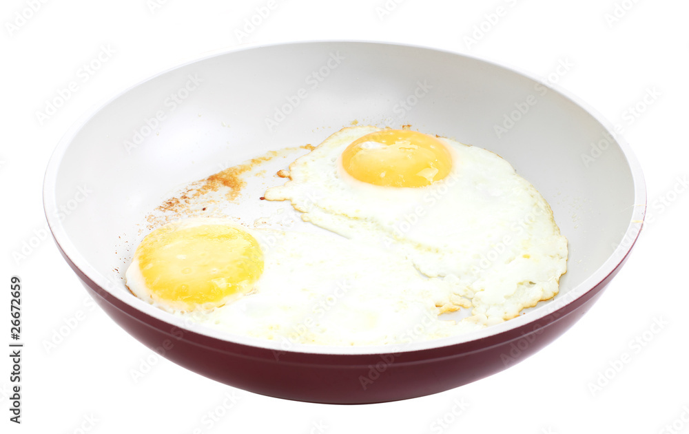 Broken egg frying in a pan isolated on white Broken egg frying in a pan isolated on white