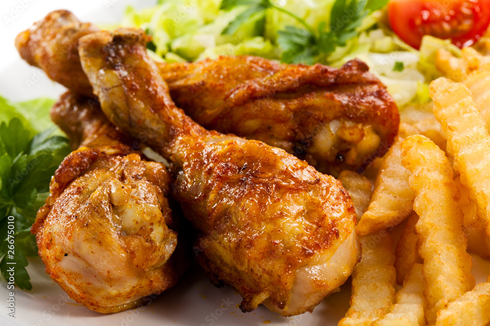 Grilled chicken drumsticks, chips and vegetables Grilled chicken drumsticks, chips and vegetables