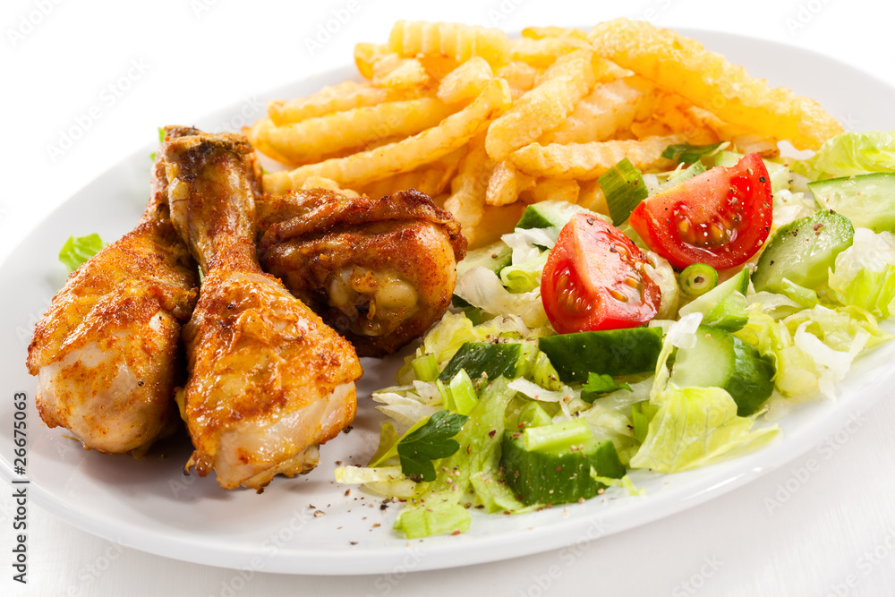 Grilled chicken drumsticks, chips and vegetables Grilled chicken drumsticks, chips and vegetables