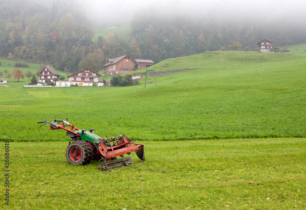 Fototapeta premium tractor standing next to the mowed grass