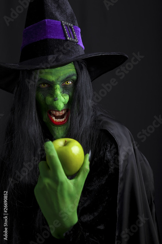 Scary witch holding an apple. photo