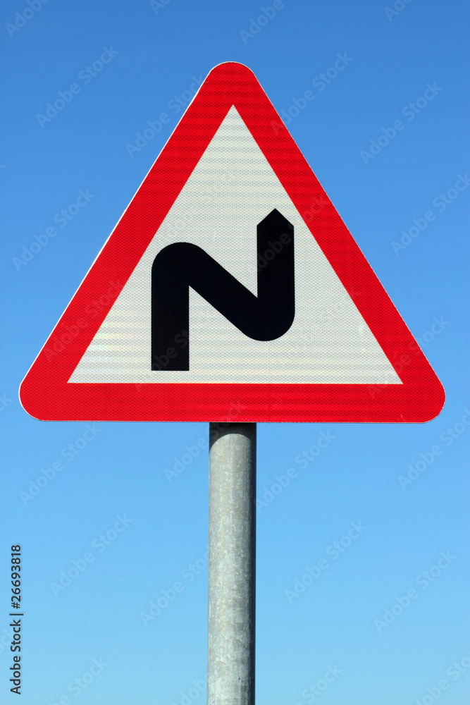 British double bend road sign and blue sky. British double bend road sign and blue sky.