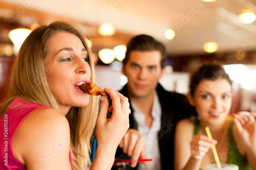 Freunde im Restaurant essen Fast-Food
