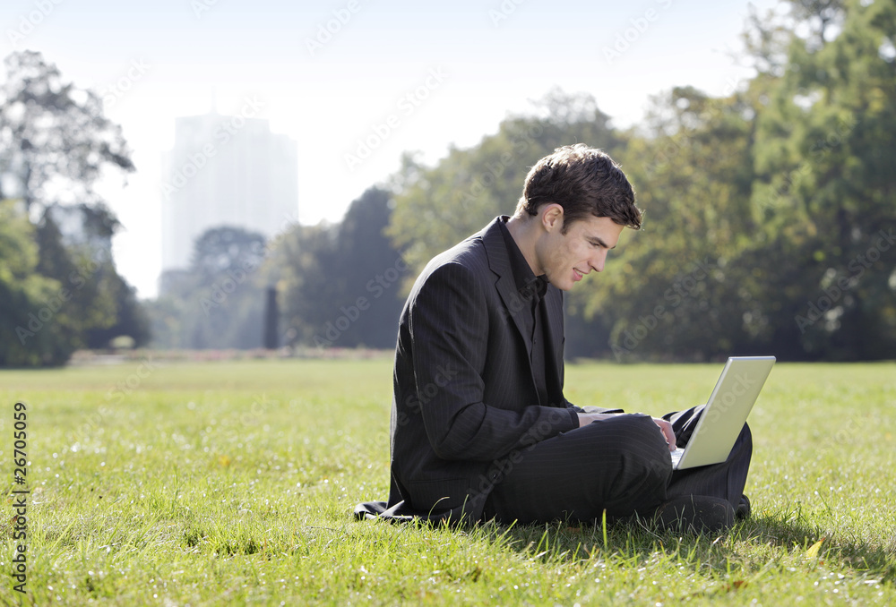 yung man with laptop sitting in the park yung man with laptop sitting in the park