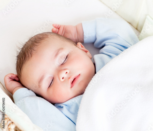 Portrait of a peaceful baby sleeping in his cradle at home