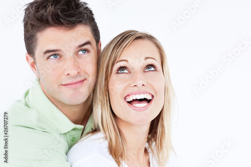 Portrait of a joyful couple looking at the top against whit back