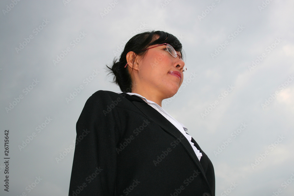 Asian business woman under a cloudy sky. Asian business woman under a cloudy sky.