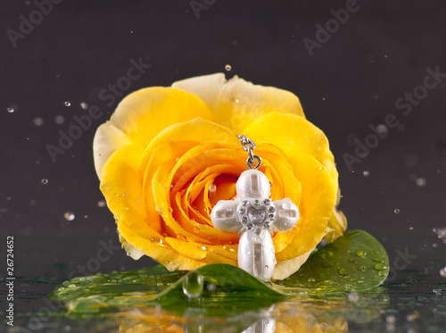 Rain Falling Down on Yellow Rose with Small Baptism Cross Fototapeta
