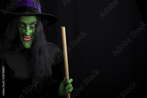 Scary witch holding a broomstick