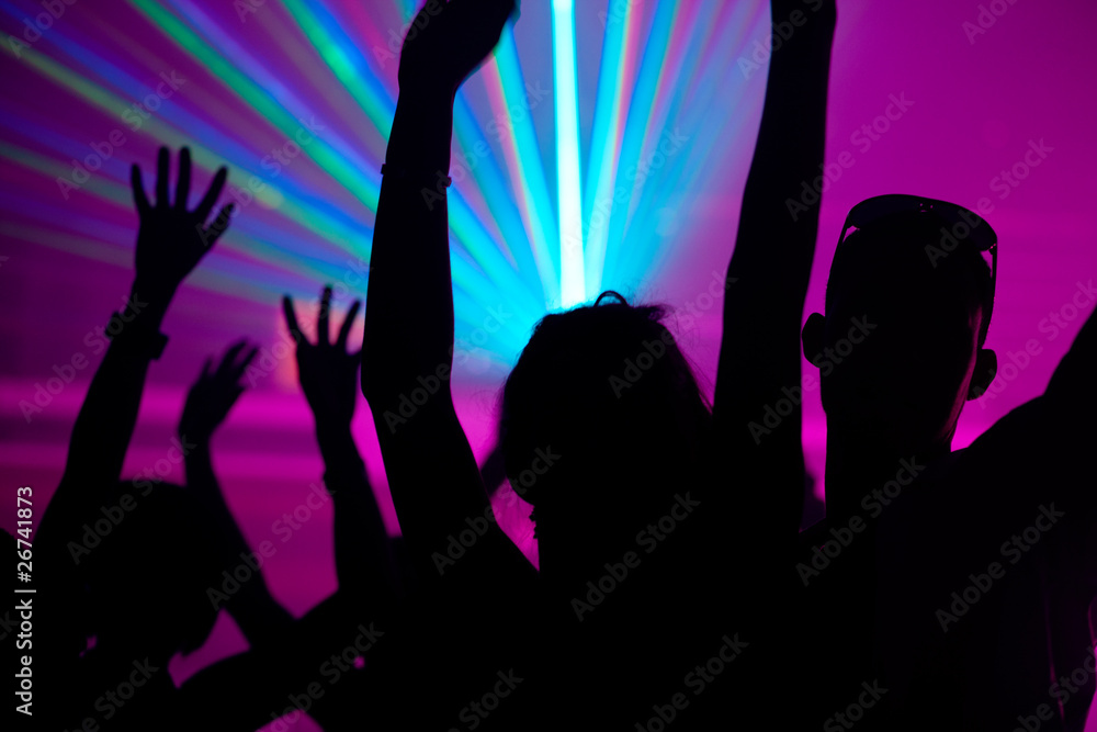 People dancing in club with laser