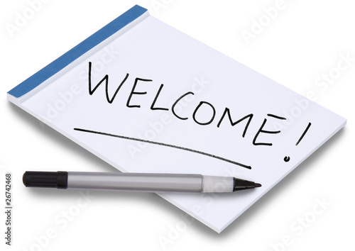 Notepad with handwritten Welcome and pen lying on paper photo