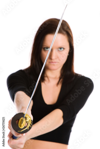 Beautiful woman in an aggressive posture with a sword katana