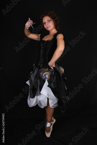 ballerina with scissors over black background