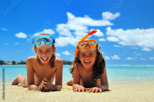 Fillettes en vacances, allongées sur le sable.