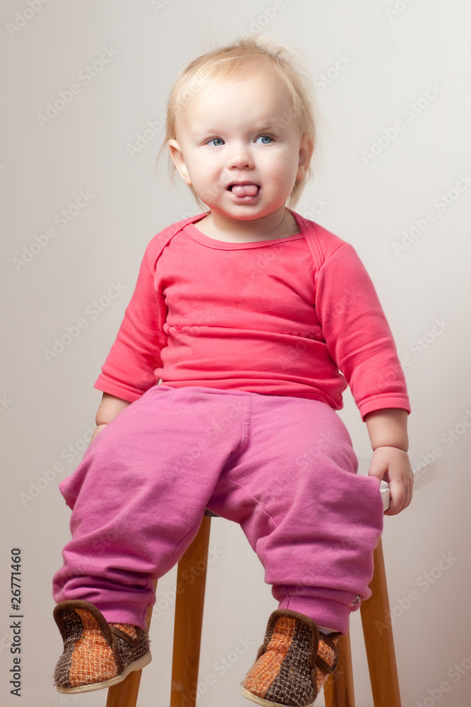 Portrait of cute young baby sit on chair and grimacing Portrait of cute young baby sit on chair and grimacing