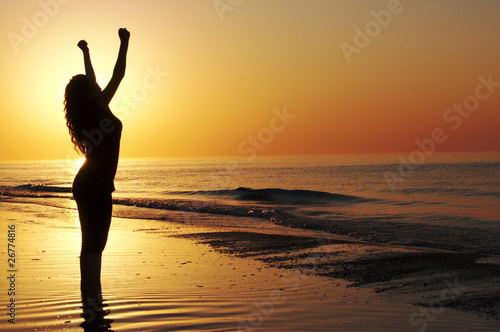 Woman showing achievement at the beach