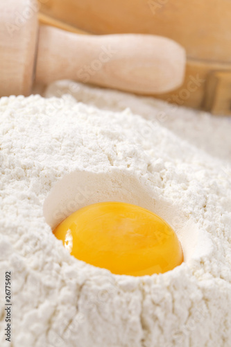 egg yolk in flour, rolling pin ang sieve on background