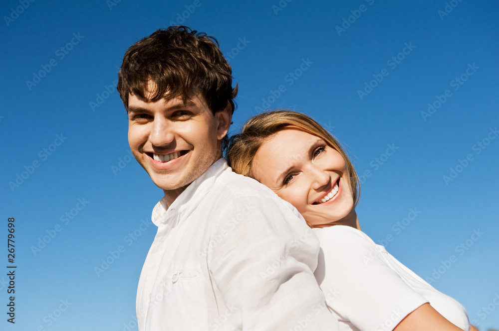 Portrait of beautiful couple on blue sky background Portrait of beautiful couple on blue sky background
