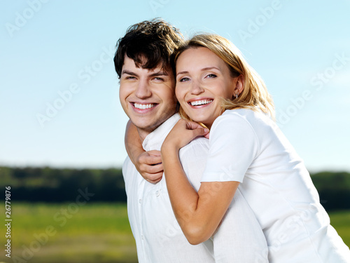happy laughing beautiful couple posing on nature