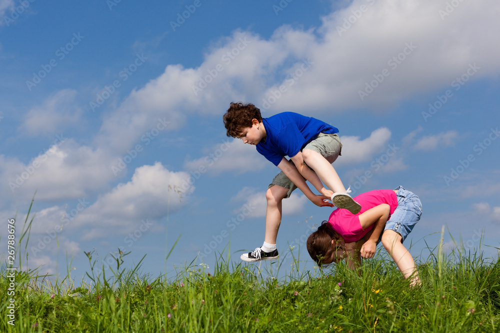 Girl and boy jumping, running against blue sky Girl and boy jumping, running against blue sky