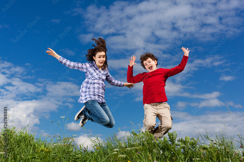 Girl and boy jumping, running against blue sky Girl and boy jumping, running against blue sky